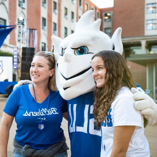 A family poses for a photo with the Billiken on homecoming weekend